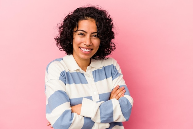 Jovem mulher latina encaracolada isolada no fundo rosa, rindo e se divertindo.