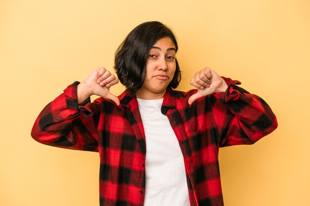 Jovem mulher latina isolada em fundo amarelo sente-se orgulhosa e autoconfiante, exemplo a seguir.