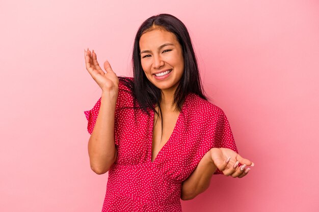 Foto jovem mulher latina isolada em fundo rosa confuso e duvidoso encolhendo os ombros para manter um espaço de cópia