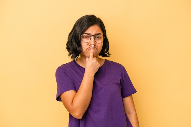 Jovem mulher latina isolada em um fundo amarelo pensando e olhando para cima, sendo reflexiva, contemplando, tendo uma fantasia.