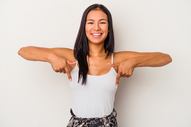 Foto jovem mulher latina isolada no fundo branco aponta para baixo com os dedos, sentimento positivo.