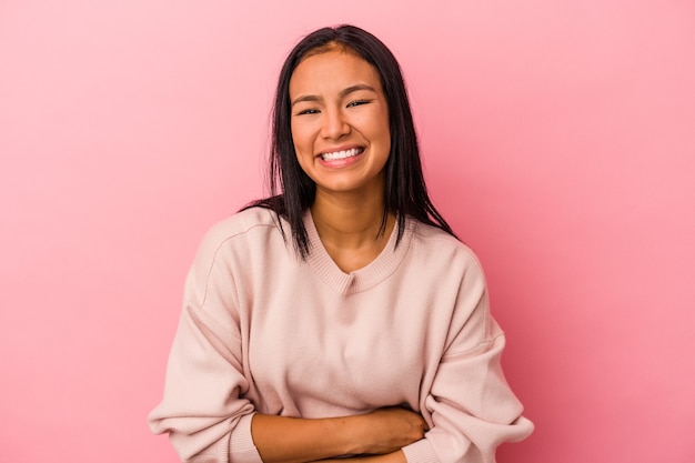 Jovem mulher latina isolada no fundo rosa, rindo e se divertindo.