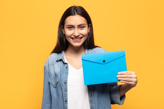 Jovem mulher latina parecendo feliz e agradavelmente surpresa, animada com uma expressão de fascínio e choque