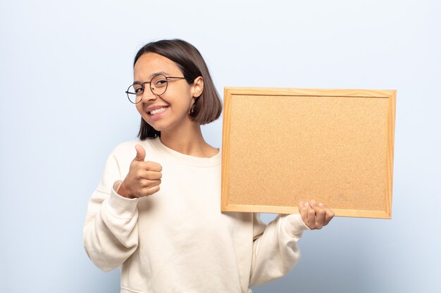 Jovem mulher latina se sentindo orgulhosa, despreocupada, confiante e feliz, sorrindo positivamente com o polegar para cima