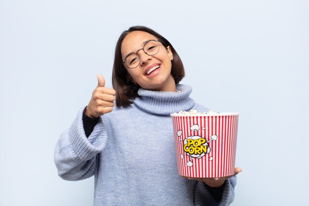 Jovem mulher latina se sentindo orgulhosa, despreocupada, confiante e feliz, sorrindo positivamente com o polegar para cima