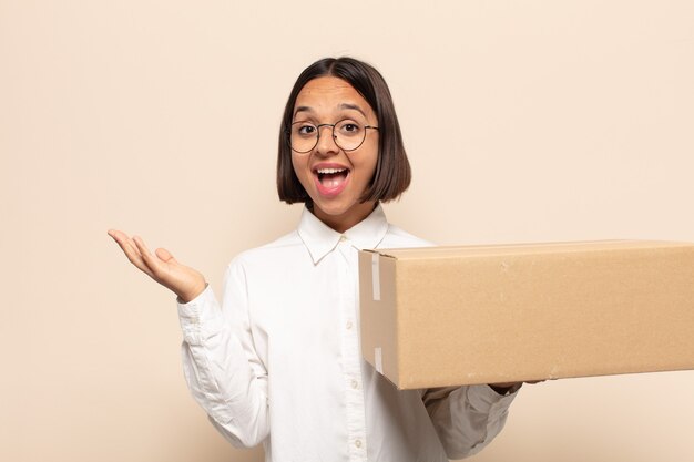 Jovem mulher latina sentindo-se feliz, surpresa e alegre, sorrindo com atitude positiva, percebendo uma solução ou ideia