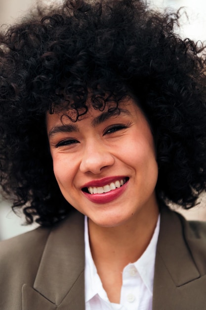 Jovem mulher latina sorridente com cabelo afro encaracolado