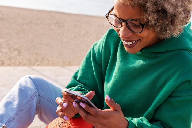 Jovem mulher latina sorrindo feliz usando seu telefone