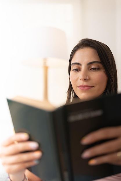 Jovem mulher lendo um livro de capa dura