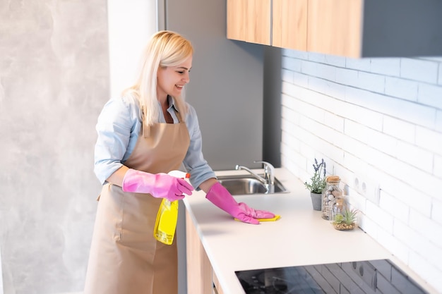 Jovem mulher limpando armários de cozinha