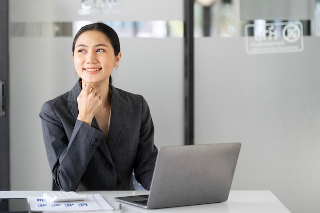 Jovem mulher linda e alegre sorrindo enquanto trabalha com laptop