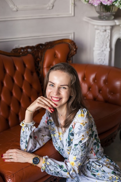 Jovem mulher linda em um vestido floral sentada no chão