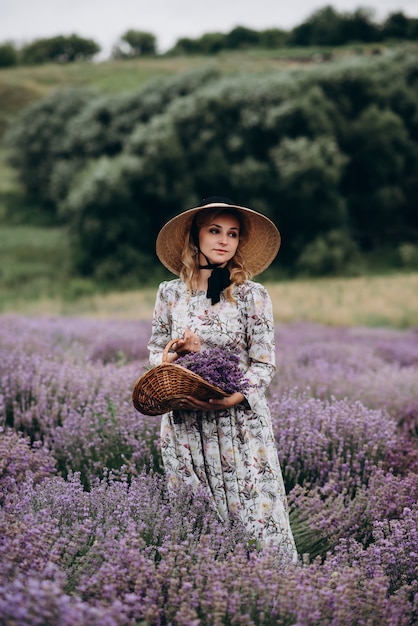 Jovem mulher linda em um vestido romântico no campo de lavanda