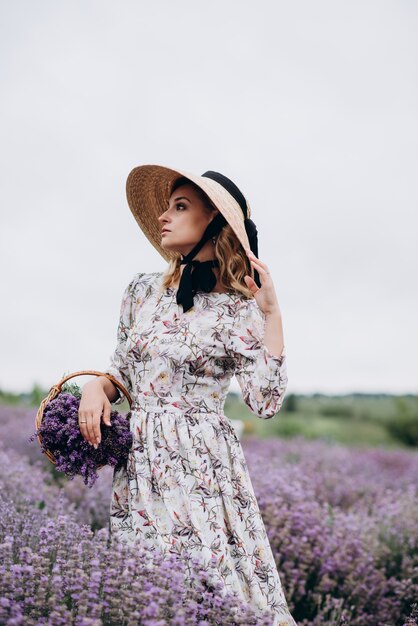 Jovem mulher linda em um vestido romântico no campo de lavanda