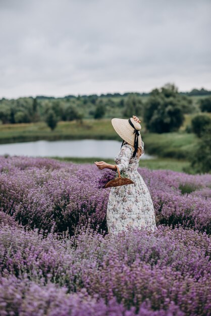 Jovem mulher linda em um vestido romântico no campo de lavanda