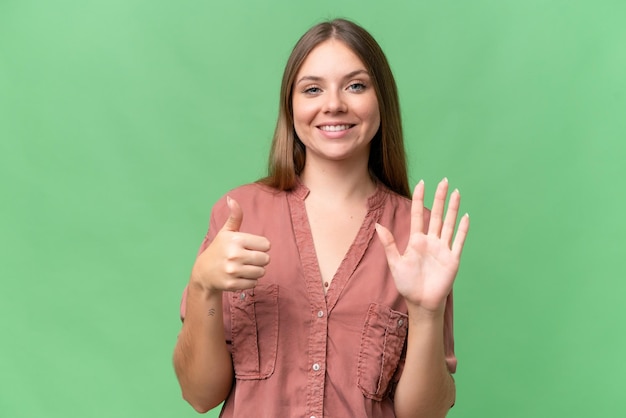 Jovem mulher loira bonita sobre fundo isolado contando seis com os dedos