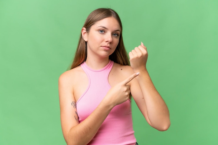 Foto jovem mulher loira bonita sobre fundo isolado fazendo o gesto de estar atrasado