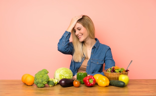 Jovem mulher loira com muitos vegetais percebeu algo e pretendia a solução