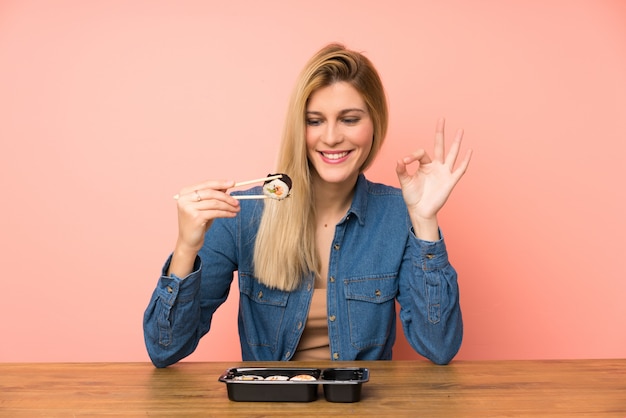 Foto jovem mulher loira comendo sushi