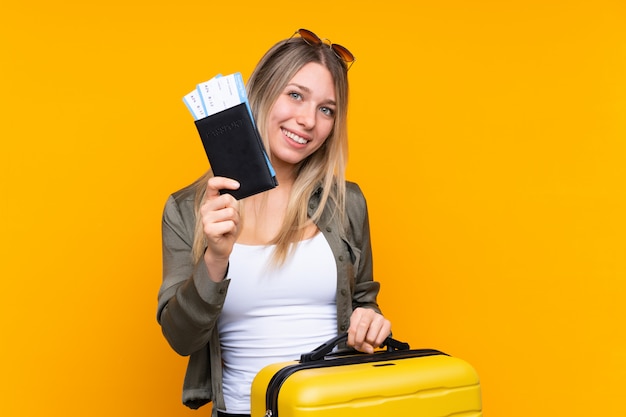 Foto jovem mulher loira de férias com mala e passaporte