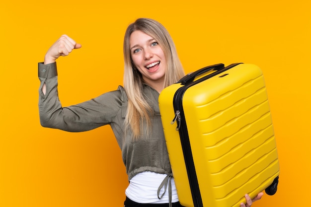 Jovem mulher loira em férias com mala de viagem