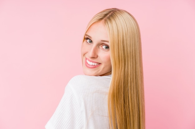 Jovem mulher loira rosto closeup em uma parede rosa