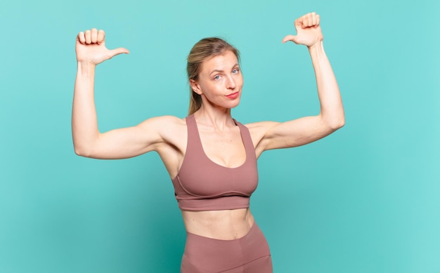 Jovem mulher loira se sentindo orgulhosa, arrogante e confiante, parecendo satisfeita e bem-sucedida, apontando para si mesma. conceito de esporte