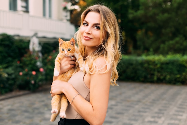 Jovem mulher loira segura um pequeno gato