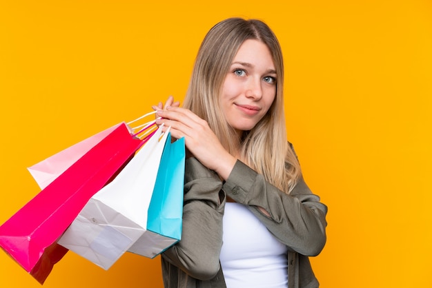 Jovem mulher loira segurando sacolas de compras