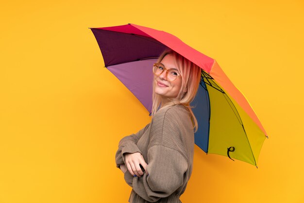 Jovem mulher loira segurando um guarda-chuva rindo