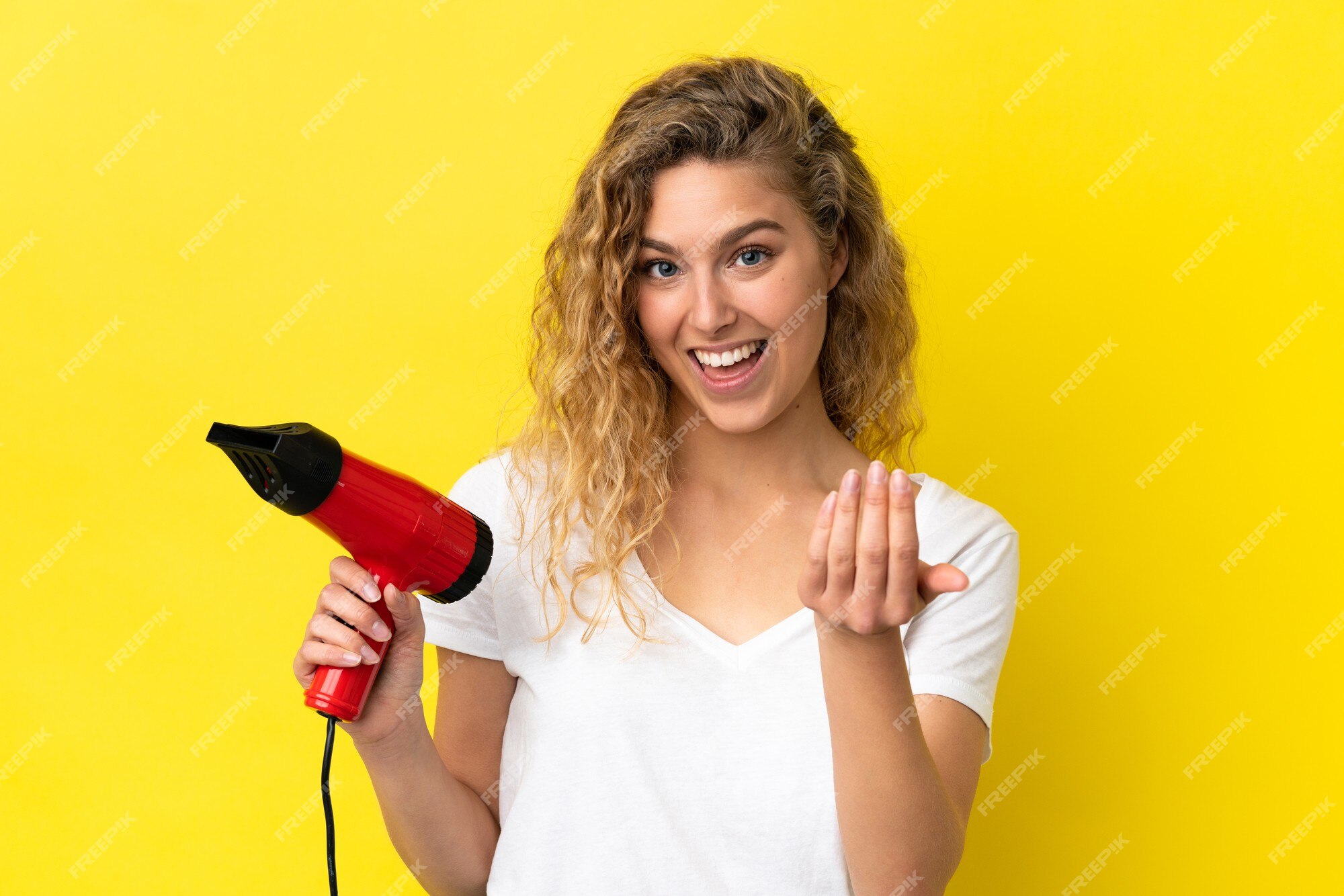 Mão segurando o secador de cabelo isolado no fundo branco