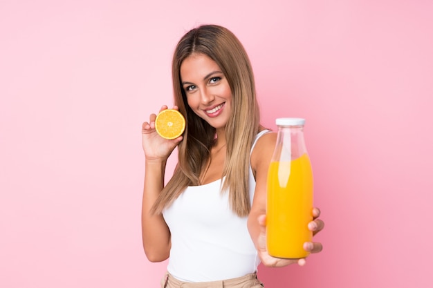 Jovem mulher loira segurando uma laranja