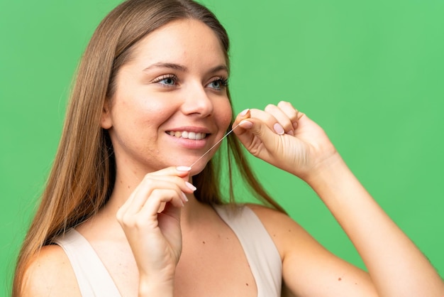 Foto jovem mulher loira sobre fundo chave de croma isolado com fio dental feche o retrato