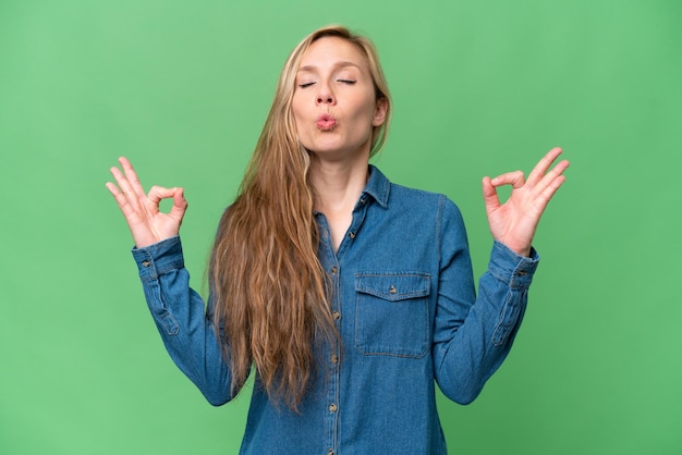 Jovem mulher loira sobre fundo isolado em pose de zen