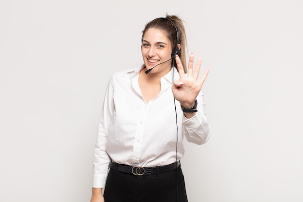 Jovem mulher loira sorrindo e parecendo amigável, mostrando o número quatro ou o quarto com a mão para a frente, em contagem regressiva