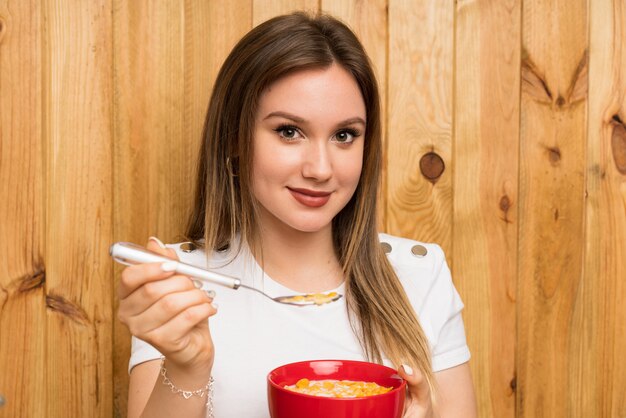 Jovem mulher loira tomando café da manhã