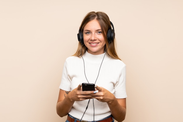 Jovem mulher loira usando o celular com fones de ouvido