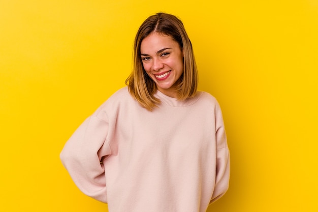 Jovem mulher magra caucasiana isolada na parede amarela feliz, sorridente e alegre.