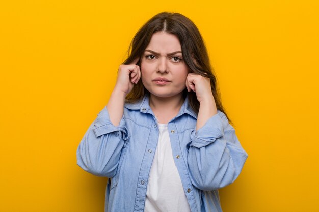 Jovem mulher mais curvilínea e mais focada em uma tarefa, mantendo os dedos indicadores apontando para a cabeça.