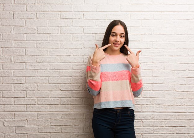 Jovem mulher moderna sorri, apontando a boca