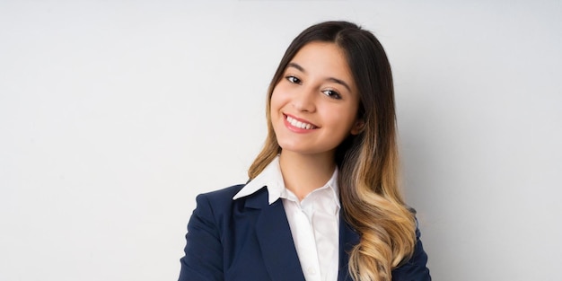 Jovem mulher morena sorrindo isolada fundo branco braços cruzados