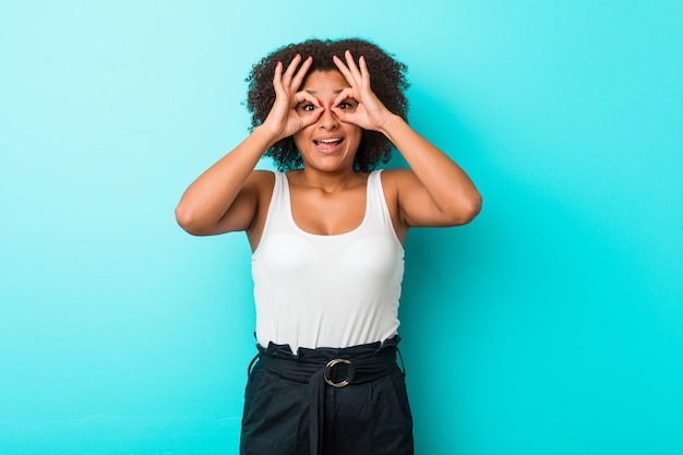 Jovem mulher mostrando sinal bem sobre os olhos