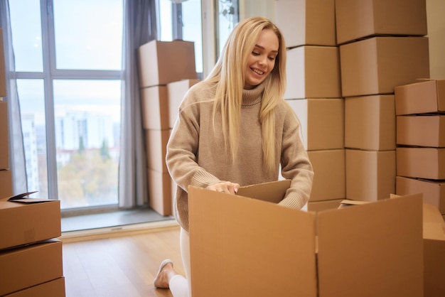 Jovem mulher movendo novo lugar e conceito de reparo jovem feliz com muitas caixas de papelão sentadas