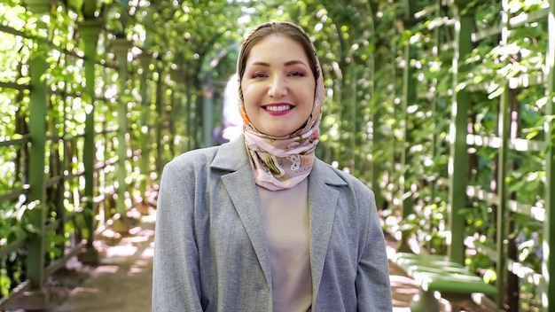 Jovem mulher muçulmana com lenço na cabeça sorrindo no parque