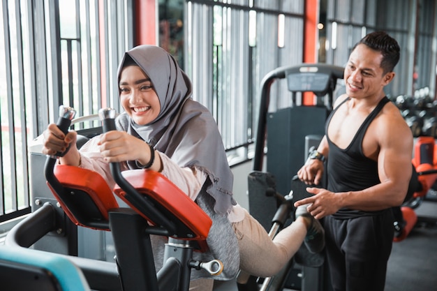 Jovem mulher muçulmana hijab fazendo costas perna pressiona