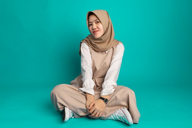 Jovem mulher muçulmana moderna vestindo roupas casuais da moda e hijab. Menina elegante sentada