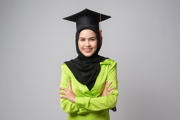 Jovem mulher muçulmana sorridente com hijab vestindo educação de chapéu de formatura e universidade conceptx9