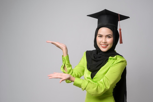 Jovem mulher muçulmana sorridente com hijab vestindo educação de chapéu de formatura e universidade conceptx9