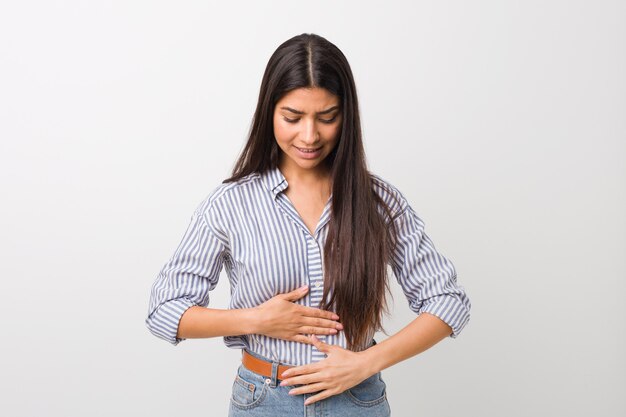 Jovem mulher muito árabe doente, sofrendo de dor de estômago, o conceito de doença dolorosa.