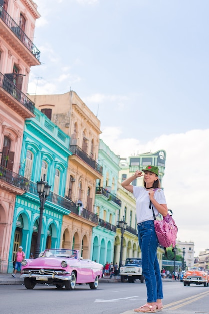 Jovem mulher na área popular em havana velha, cuba. viajante de menina bonita, casas coloridas na cidade